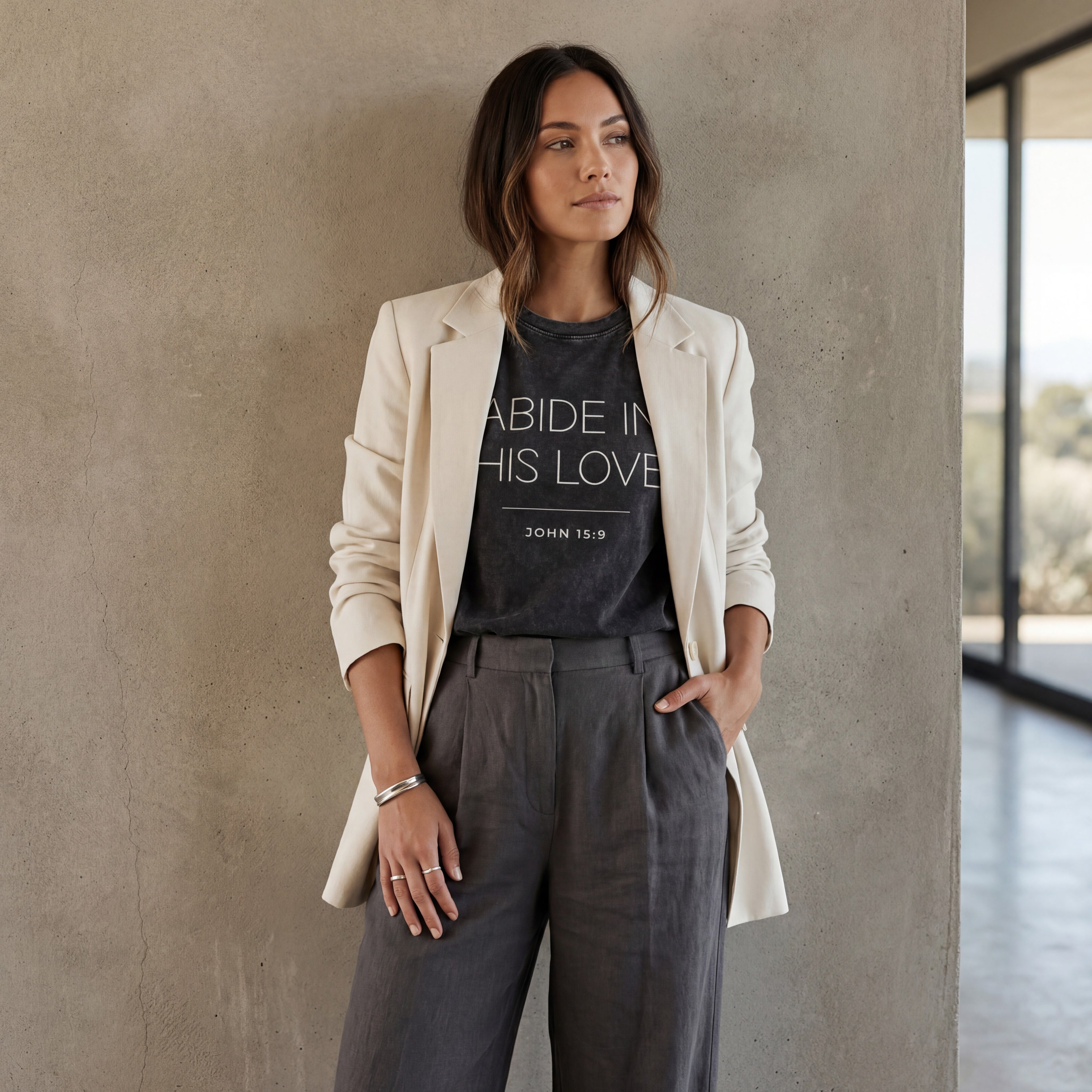 Woman wearing "abide in his love john 15:9" vintage black mineral‑wash graphic tee styled minimally in soft natural light with a calm, modern look.