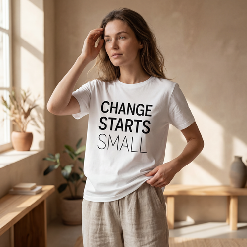 Woman wearing the "change starts small" motivational t shirt in warm natural sunlight with a peaceful, reflective mood.