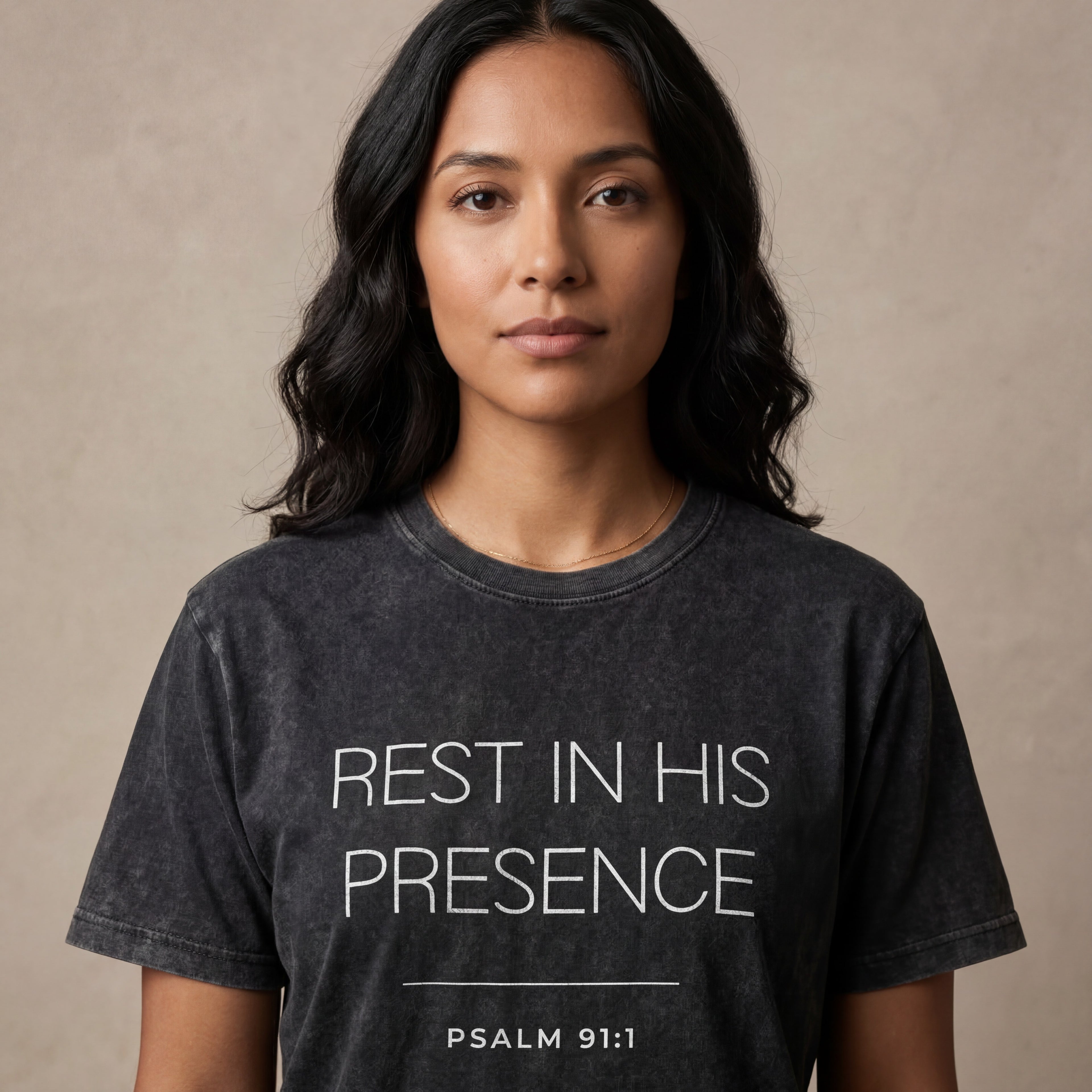 Woman wearing the "rest in his presence psalm 91:1" minimalist graphic tee in a soft neutral studio setting, calm and welcoming.