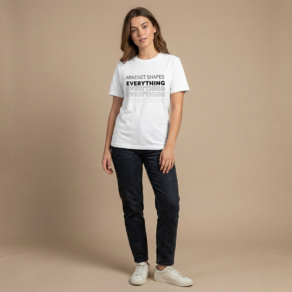 Woman wearing the "mindset shapes everything" minimalist graphic tee with gentle movement and a warm, approachable expression.