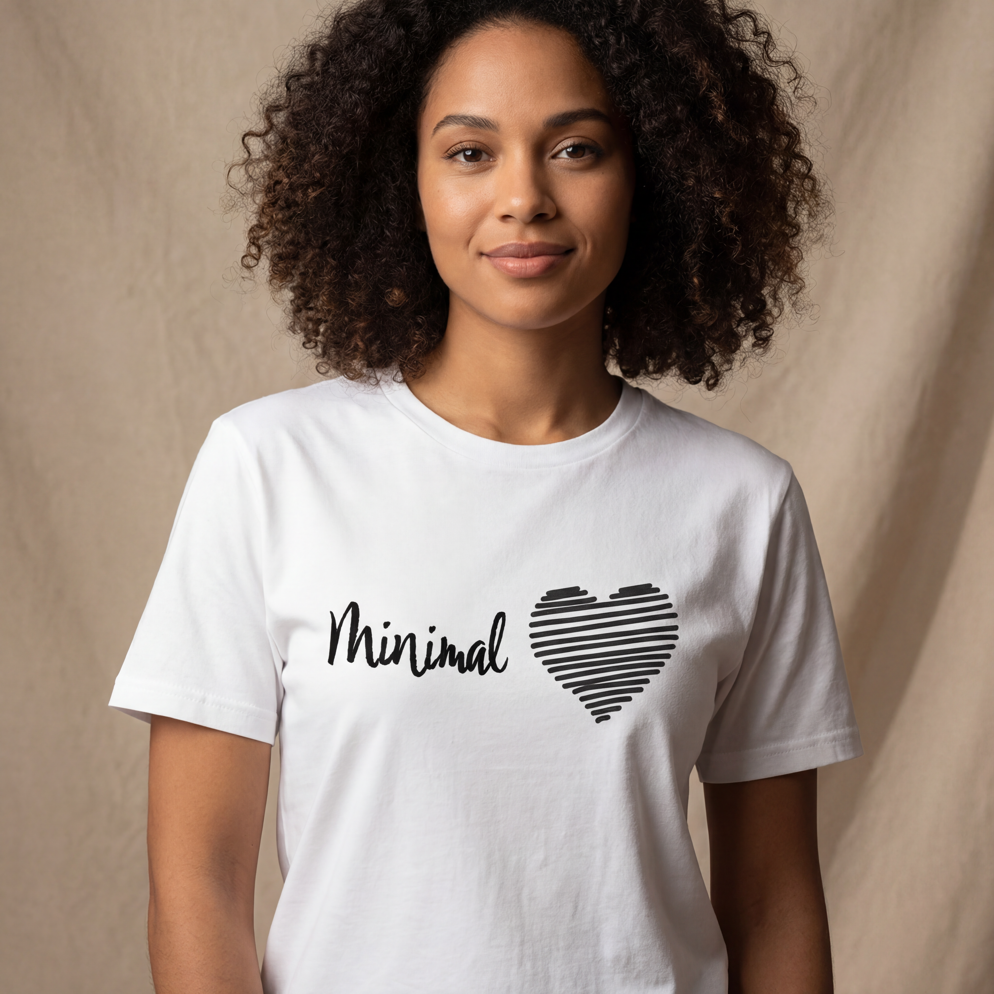 Woman wearing the minimal love minimalist graphic tee in a soft neutral studio setting, calm and welcoming.