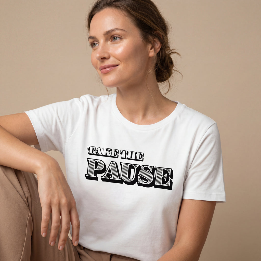 Side‑angle studio view of a woman wearing the Taek the pause minimalist graphic tee with a calm, natural expression.