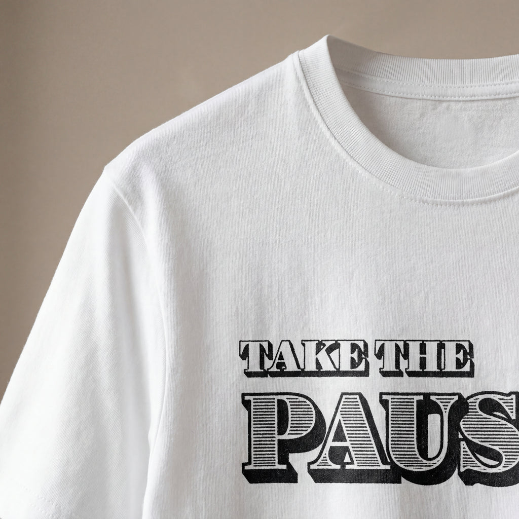 Close‑up of the take the pause organic cotton t‑shirt showing soft fabric texture and clean printed text.