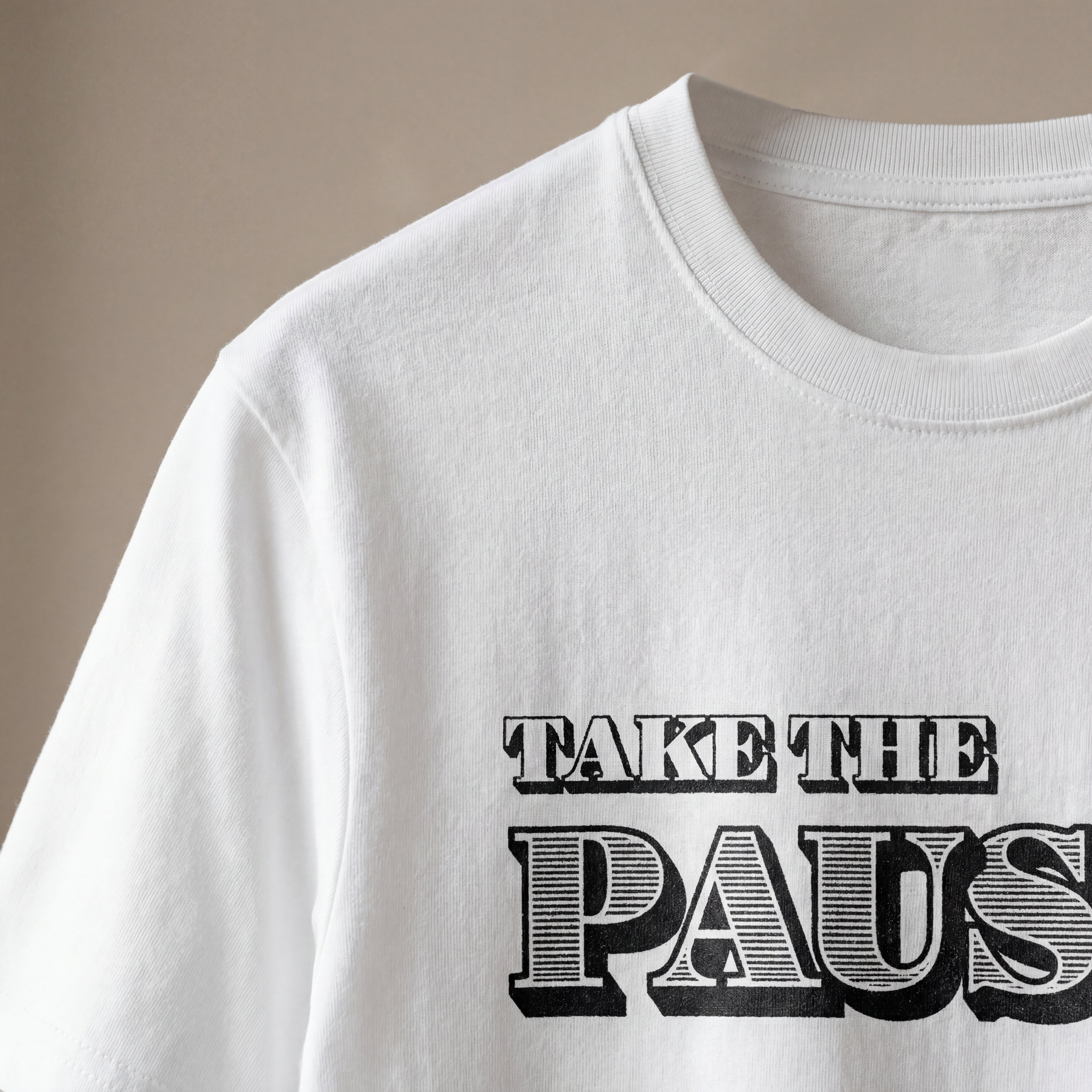 Close‑up of the take the pause organic cotton t‑shirt showing soft fabric texture and clean printed text.